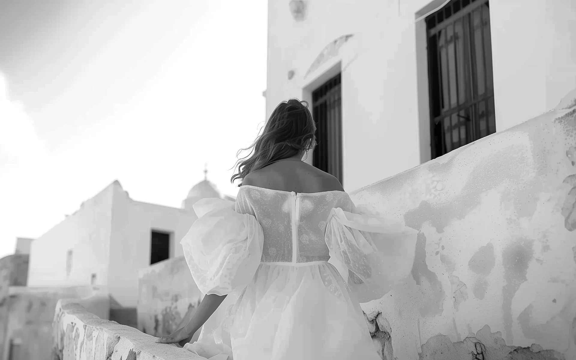 Bride in an elegant white dress walking through traditional Mediterranean architecture in Cyprus